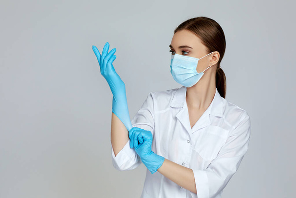 doctor in white uniform wearing mask and rubber gloves - Fotó, kép