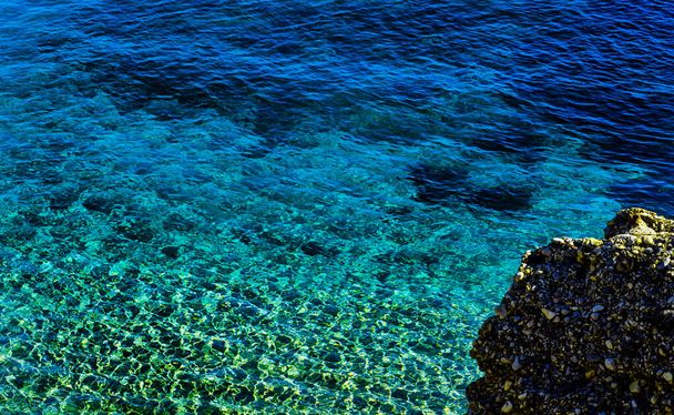 Niesamowite morze z błękitną letnią falą i skałami, relaksujący widok na skały i wodę, przyroda - Zdjęcie, obraz