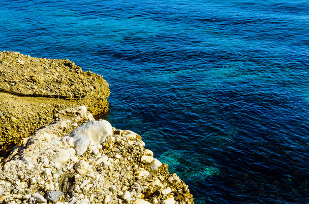 Удивительное море с голубой летней волной и скалами, расслабляющий вид на скалы и воду, природу
 - Фото, изображение
