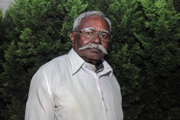Oude Indiase man met witte snor en bril poseren voor foto - Foto, afbeelding