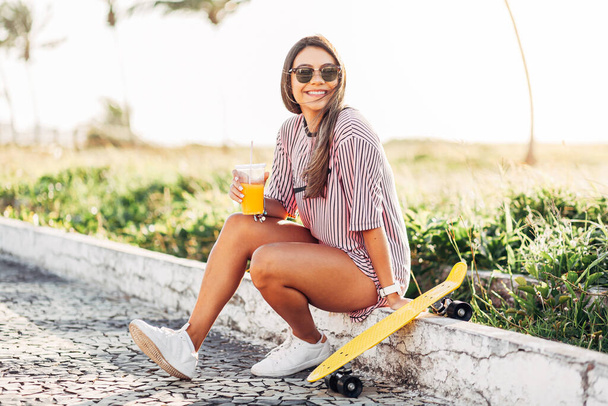 Portrait of skater woman on the beach enjoying a sunny day - Foto, immagini