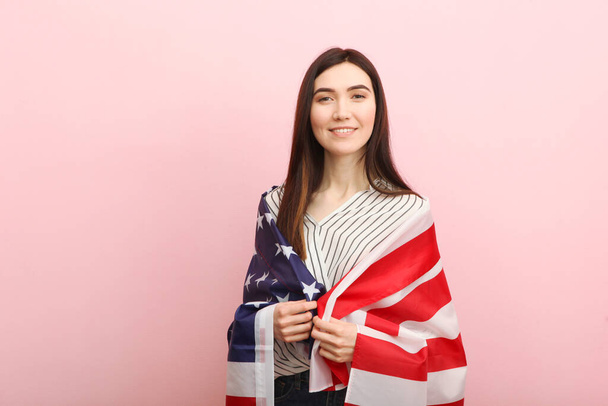 Amerika bayrağını renkli bir arka planda tutan güzel bir genç kız.. - Fotoğraf, Görsel