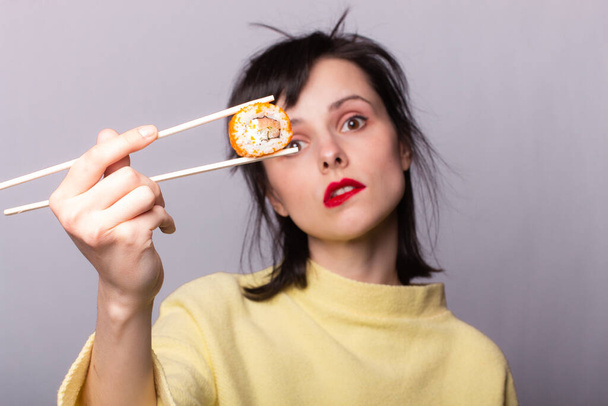 Woman eating sushi with chopsticks, rolls, asia, japan - Фото, зображення