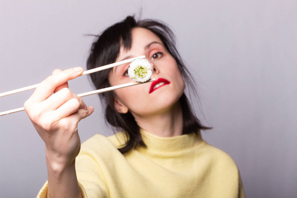 Woman eating sushi with chopsticks, rolls, asia, japan - Foto, imagen