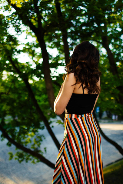 brunette walks through the streets of Lviv in a beautiful long dress. - Фото, изображение