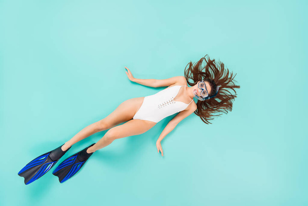 Full body high angle above flat lay photo of funky lady swimming ocean water see coral reef view using flippers tube mask wear bodysuit isolated pastel teal color background - Photo, image