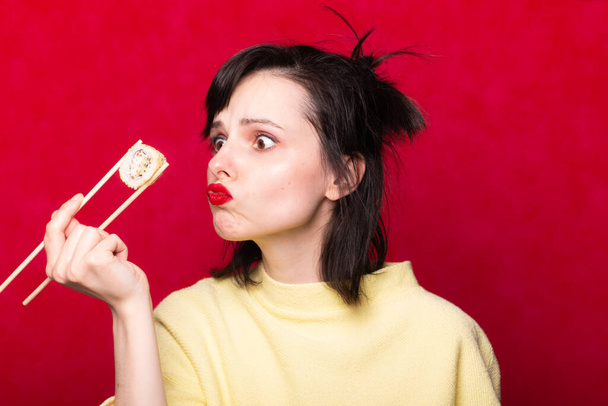Woman with red lips on a light background eating sushi. asian food - Foto, afbeelding