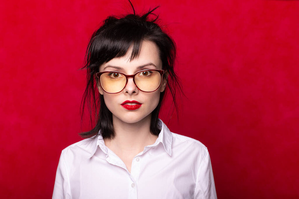 vrouwelijke manager met rode lippen, rode achtergrond - Foto, afbeelding