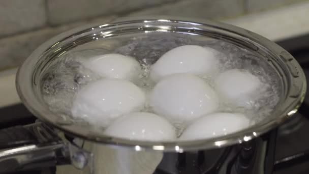 Αυγά κοτόπουλου σε κατσαρόλα με βραστό νερό στη σόμπα αερίου. Πρωινό μαγείρεμα - Πλάνα, βίντεο