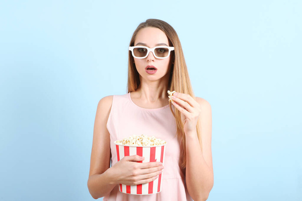 girl with popcorn on a colored background. Watch a movie, 3D movie. - Foto, Imagen