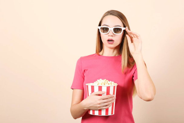 girl with popcorn on a colored background. Watch a movie, 3D movie. - Photo, Image