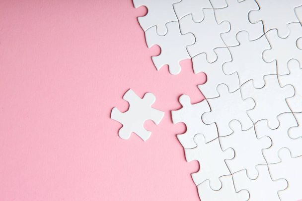 White puzzle on a colored background top view. - Foto, afbeelding