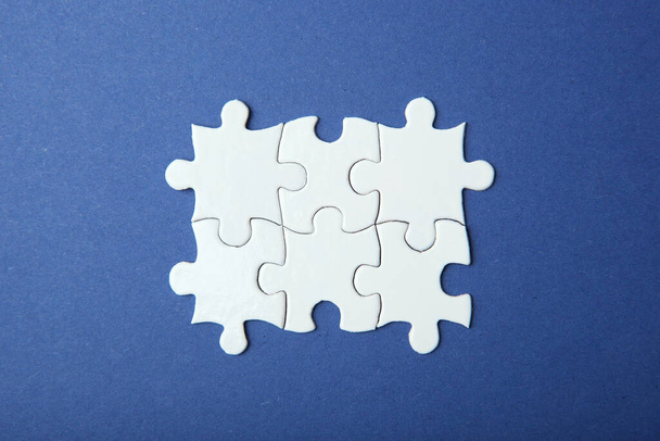 White puzzle on a colored background top view. - Foto, imagen