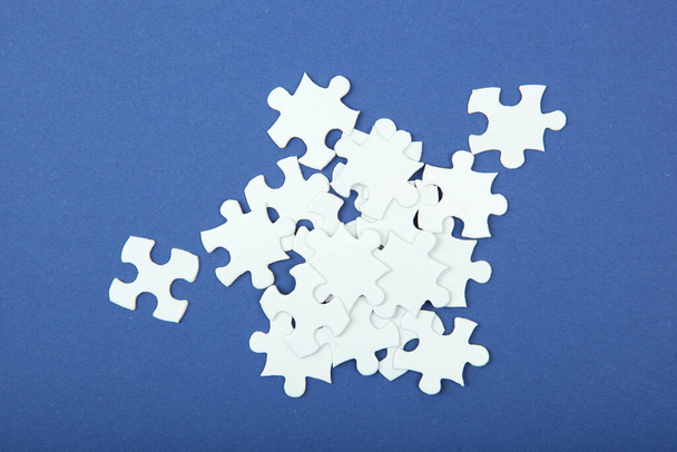 White puzzle on a colored background top view. - Photo, Image