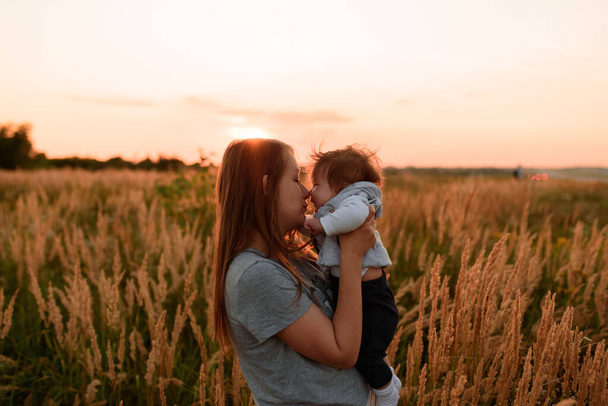 Une mère marche dans les champs avec sa petite fille dans les bras
. - Photo, image