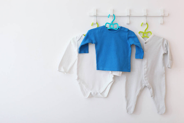 Babykleidung auf einem Kleiderbügel. Platz für Text, Minimalismus. - Foto, Bild