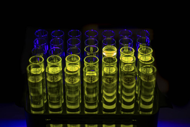 Светящийся раствор зеленых соединений, собранный из колонной хроматографии в многократной пробирке в химической лаборатории для фармацевтических исследований
 - Фото, изображение