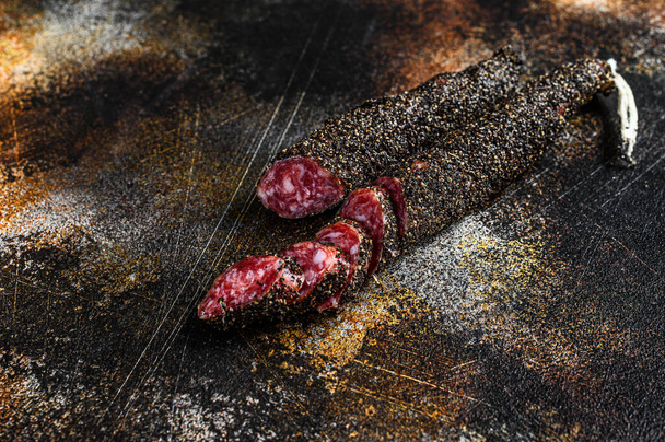 Fuet, Salami. Traditional Spanish sausage. Black background. Top view. - Фото, изображение