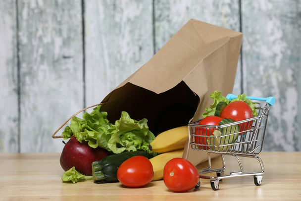 nákupní košík s potravinami. Recyklovaný papírový nákupní taška se zeleninou .na dřevěném pozadí. Eko produkt. Zelenina. Salát - Fotografie, Obrázek