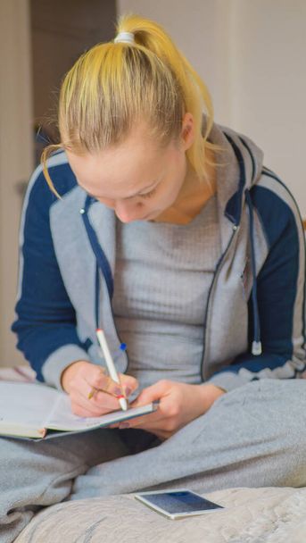 Young female student preparing for home exams. - Foto, afbeelding