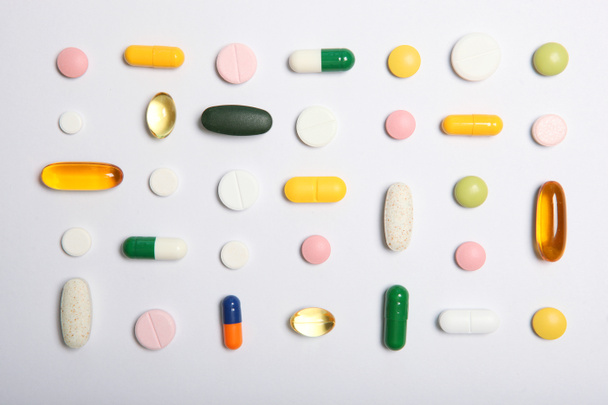 pills on a colored background top view. Medicine, treatment, illness. Medication in tablets. - Photo, image