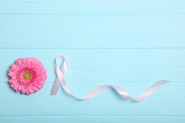 różowa wstążka i gerbera na kolorowym tle widok z góry. Symbol kobiecego raka. Świadomość nowotworów u kobiet - Zdjęcie, obraz