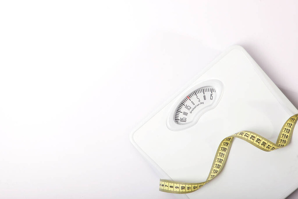 floor scales and tape measure on a colored background top view. Healthy lifestyle concept, healthy eating. Body weight control. - Foto, Imagen