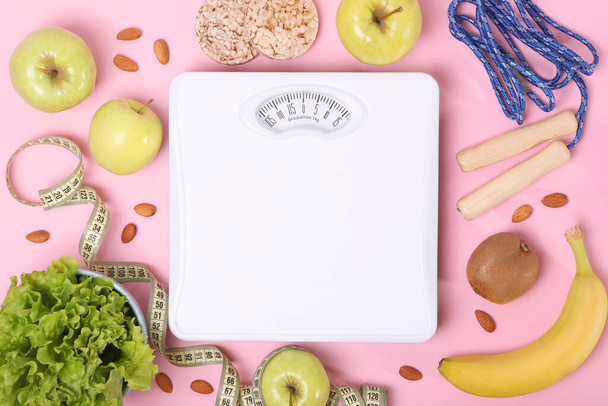 floor scales, tape measure and healthy products on a colored background top view. The concept of a healthy diet, body weight control. Healthy lifestyle. - Photo, Image