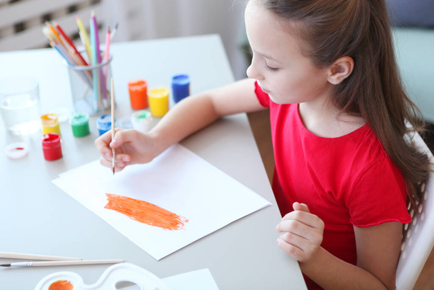 Schattig klein meisje tekent verf thuis. - Foto, afbeelding