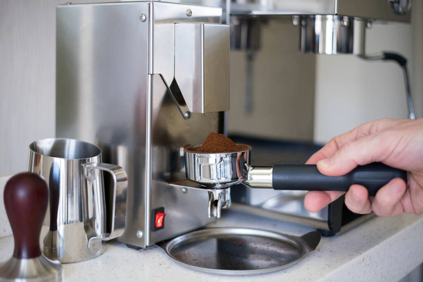 Kahveyi espresso makinesinin portafilterine öğüt, seçici odaklanma. - Fotoğraf, Görsel