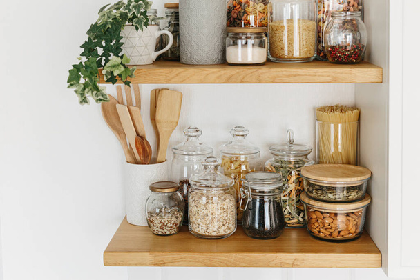 Various cereals and seeds in glass jars on the shelves in the kitchen. Kitchen interior ideas. Eco friendly kitchen, zero waste home concept - Fotografie, Obrázek