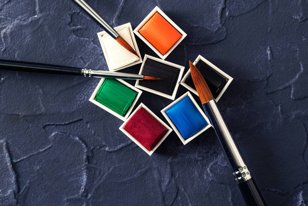 Акварельные краски и кисти, инструменты для творческой мастерской, вид сверху
 - Фото, изображение