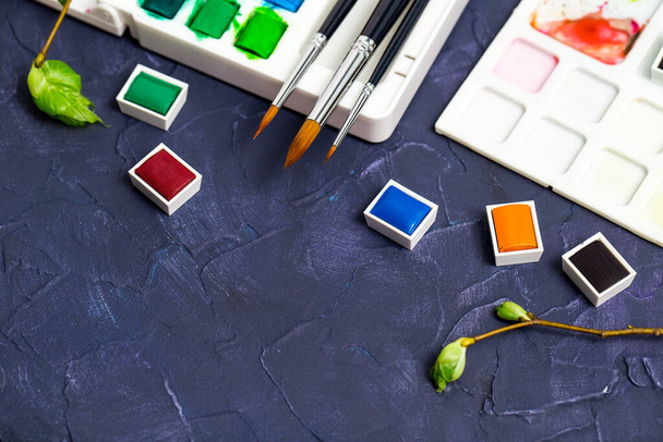 Акварельные краски и кисти, инструменты для творческой мастерской крупным планом
 - Фото, изображение