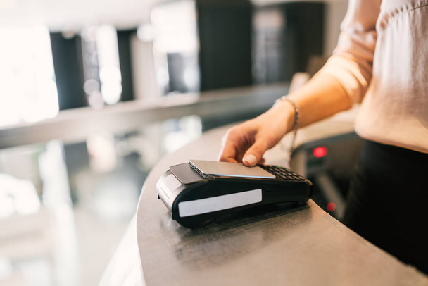 Close up of guest makes card payment at check-in at reception front desk. Travel concept. - Photo, image