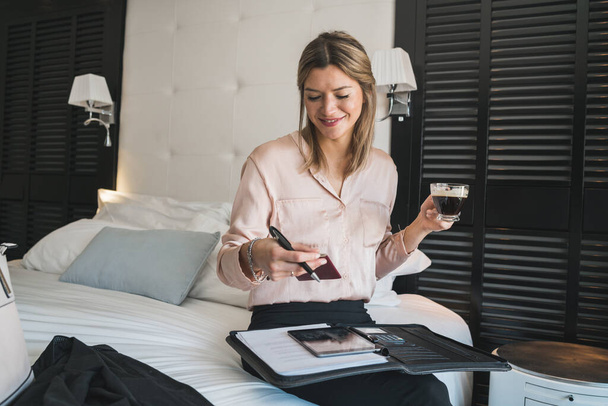 Portrait of young businesswoman working at the hotel room. Business travel concept. - Φωτογραφία, εικόνα