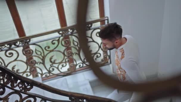 smutny facet wspina się po schodach domu - Materiał filmowy, wideo