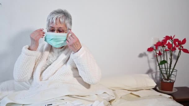 Covid-19-es. Idős nő, arcvédő maszkot visel, veszélyeztetett beteg, védelem a coronavirus influenza és a hideg ellen. - Felvétel, videó