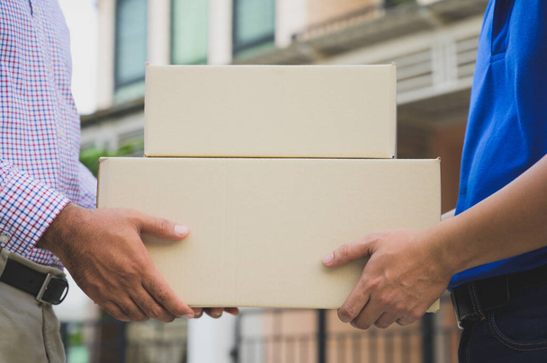 Hand accepting a delivery of boxes from deliveryman. - 写真・画像