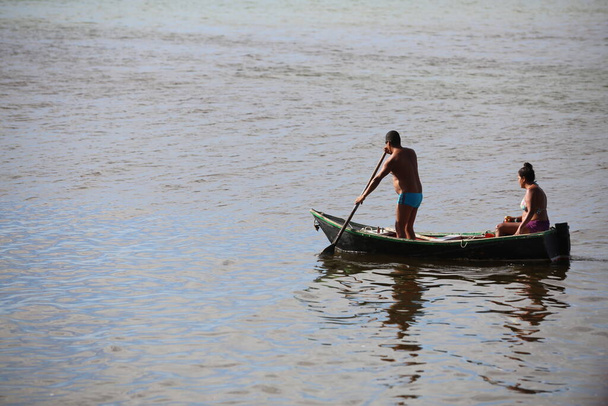 salvador, bahia / brazil -  october 25, 2017: Man rowing his boat across the Itapagipe Peninsula in the Ribeira neighborhood of Salvador. *** Local Caption *** - Fotografie, Obrázek