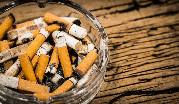 Butt cigarettes of in ashtray on table - 写真・画像