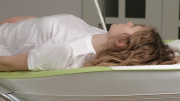 Женщина лежит на массажной электронной кровати
. - Кадры, видео