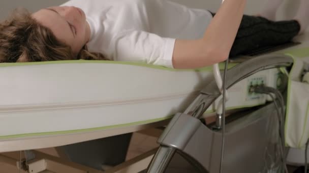 Une femme se couche sur un lit électronique de massage
. - Séquence, vidéo