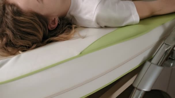 A woman lies on a massage electronic bed. - Πλάνα, βίντεο