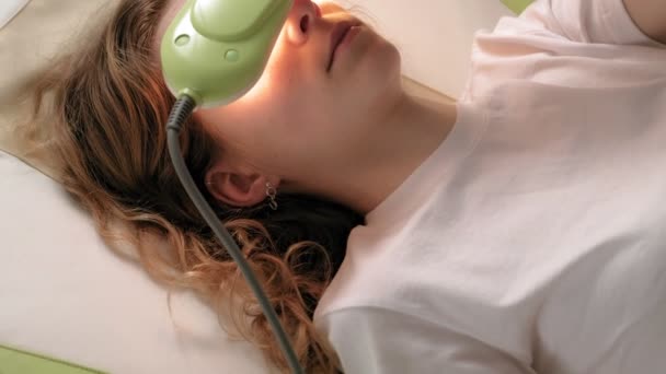 Een vrouw ligt op een massagebed met jade rollers. - Video