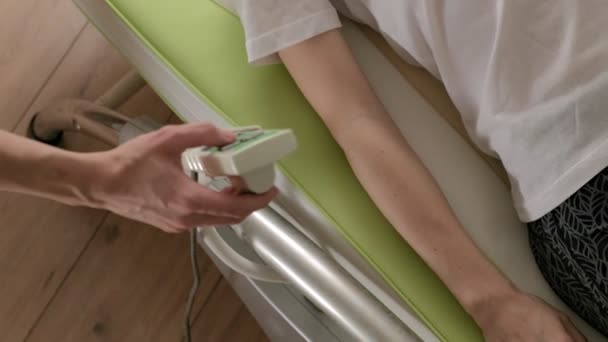 Uma mulher está em uma cama eletrônica de massagem
. - Filmagem, Vídeo
