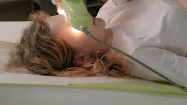 Eine Frau liegt auf einem Massagebett mit Jadewalzen. - Filmmaterial, Video