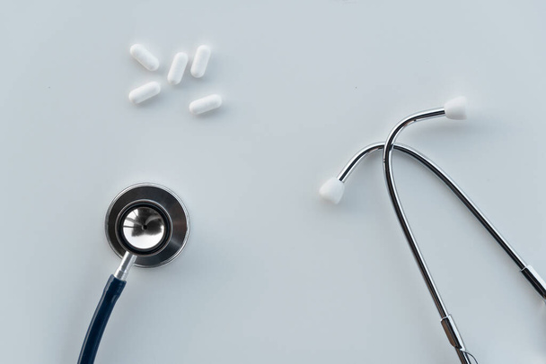 kovový stetoskop pro diagnózu onemocnění lékař a bílé léky pilulky pro léčbu pozadí     - Fotografie, Obrázek