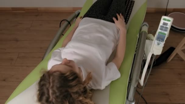 Женщина лежит на массажной электронной кровати
. - Кадры, видео