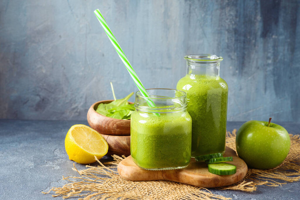 Dietní a detoxikační koncept. Zelený koktejl se špenátem, okurkou a jablkem na tmavém pozadí - Fotografie, Obrázek