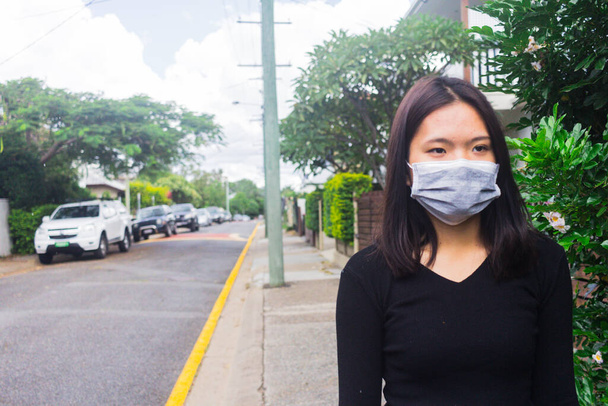 Pandémie de coronavirus asiatique jeune fille dans la rue de la ville portant un masque protecteur pour la propagation de la maladie du coronavirus 2019
. - Photo, image